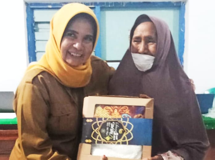 Kepala Dinas Sosial, Yuliana, saat menyerahkan bantuan sandang kepada peerima manfaat. Foto : Dok Dinsos Kota Bima